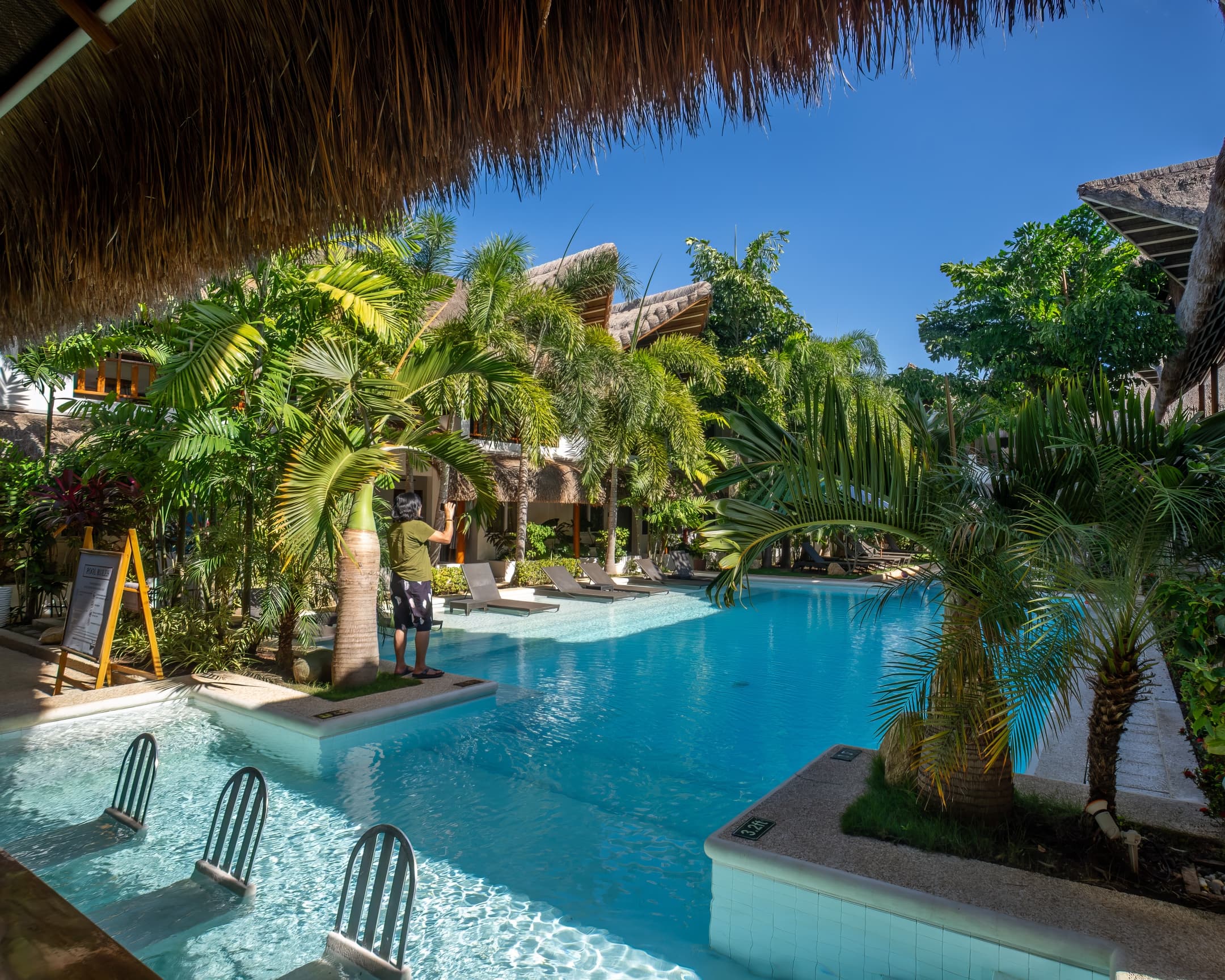 Daytime pool with tropical landscaping at Bathala Resort