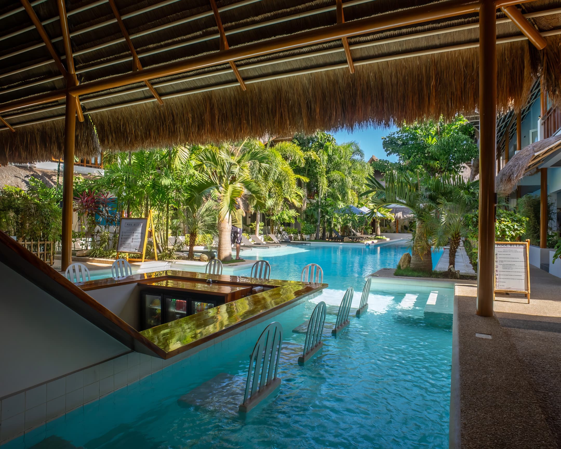 Covered swim-up pool bar looking toward the garden at Bathala Resort