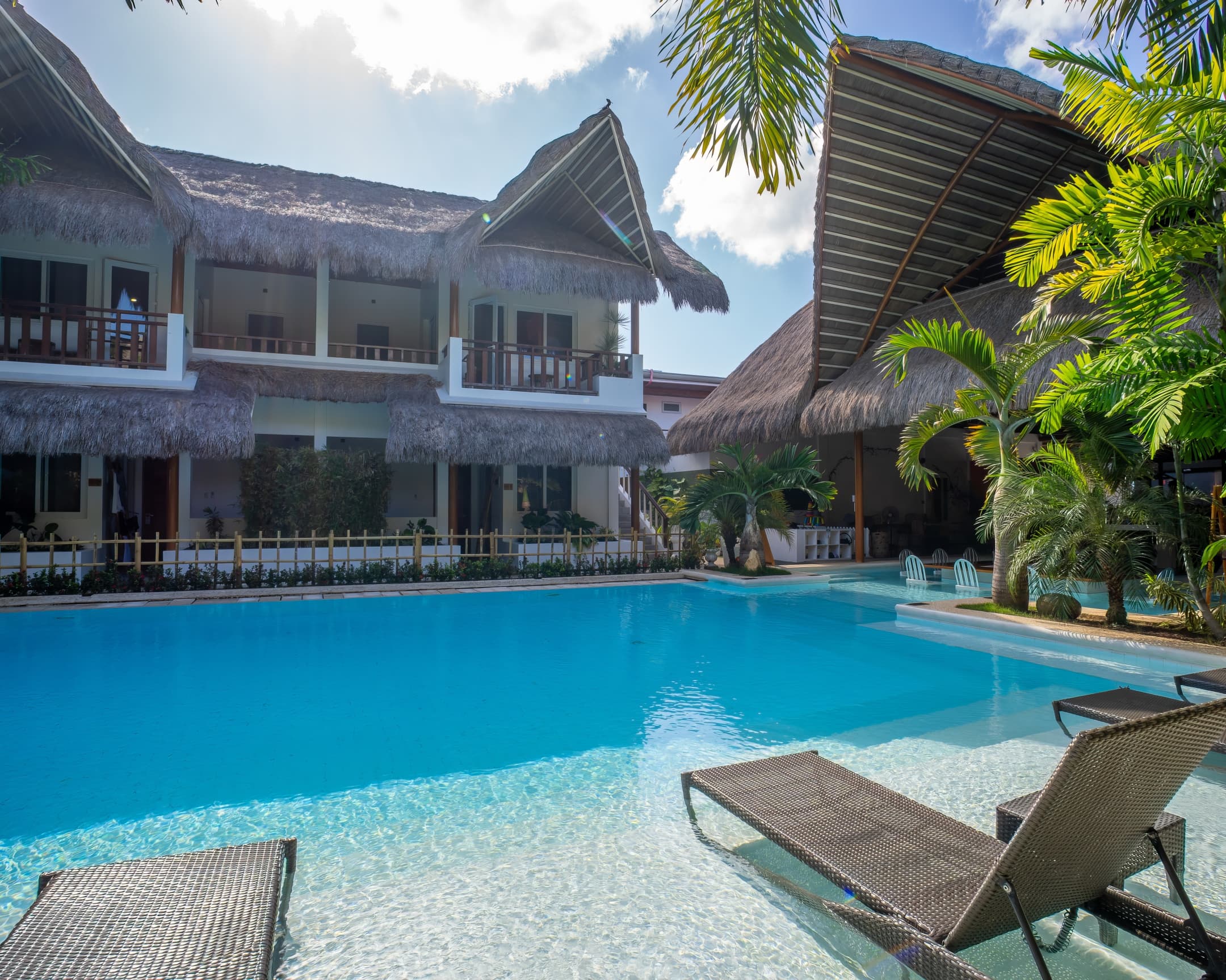 Daytime pool and guest room balconies at Bathala Resort