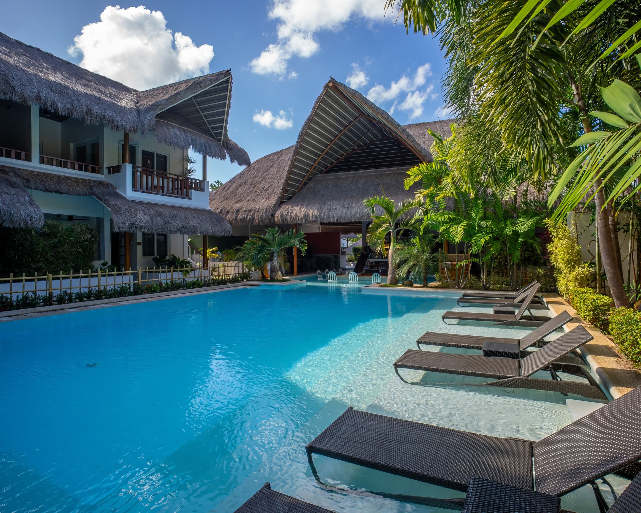 Pool loungers beside the water at Bathala Resort