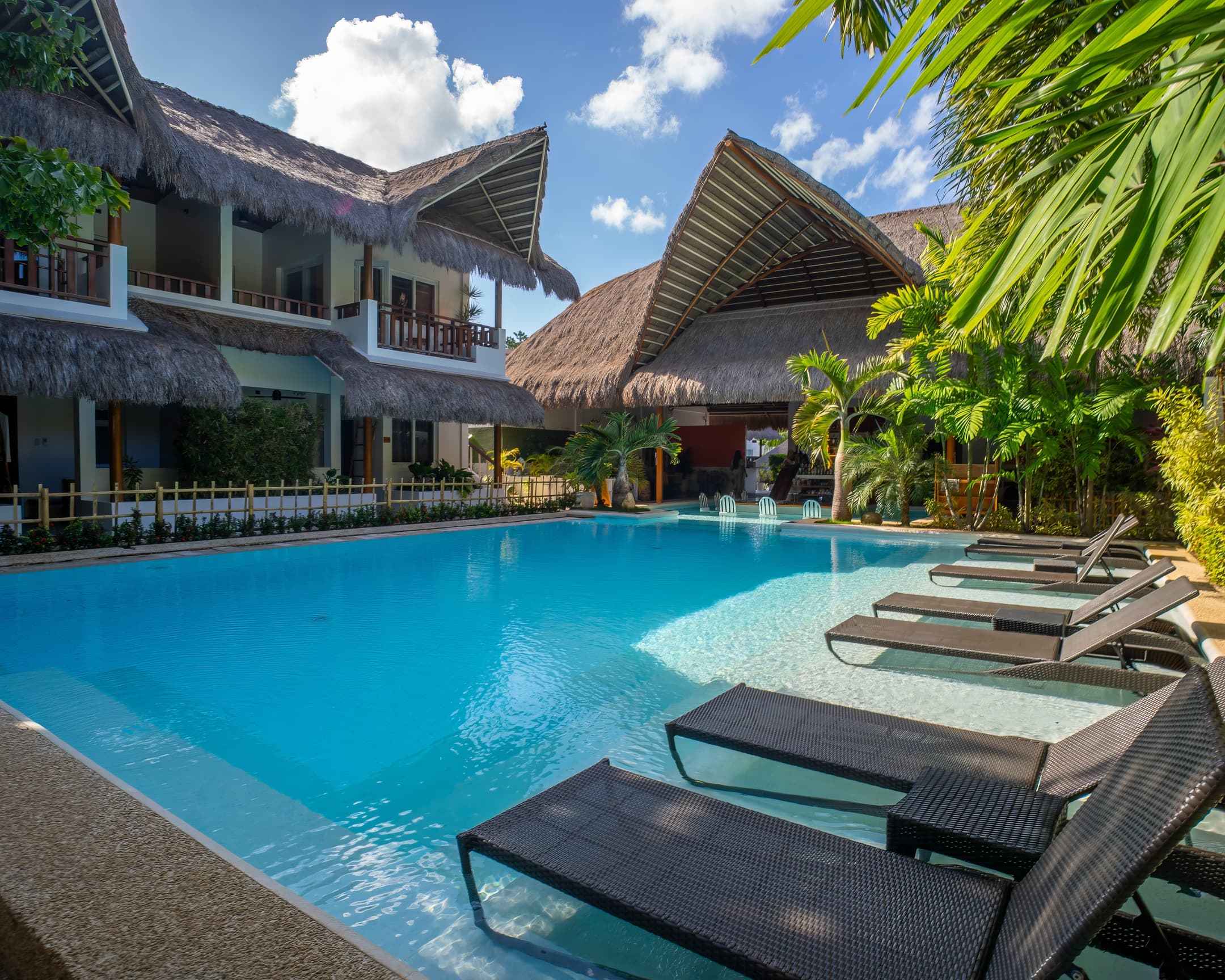 Pool loungers and tropical architecture at Bathala Resort