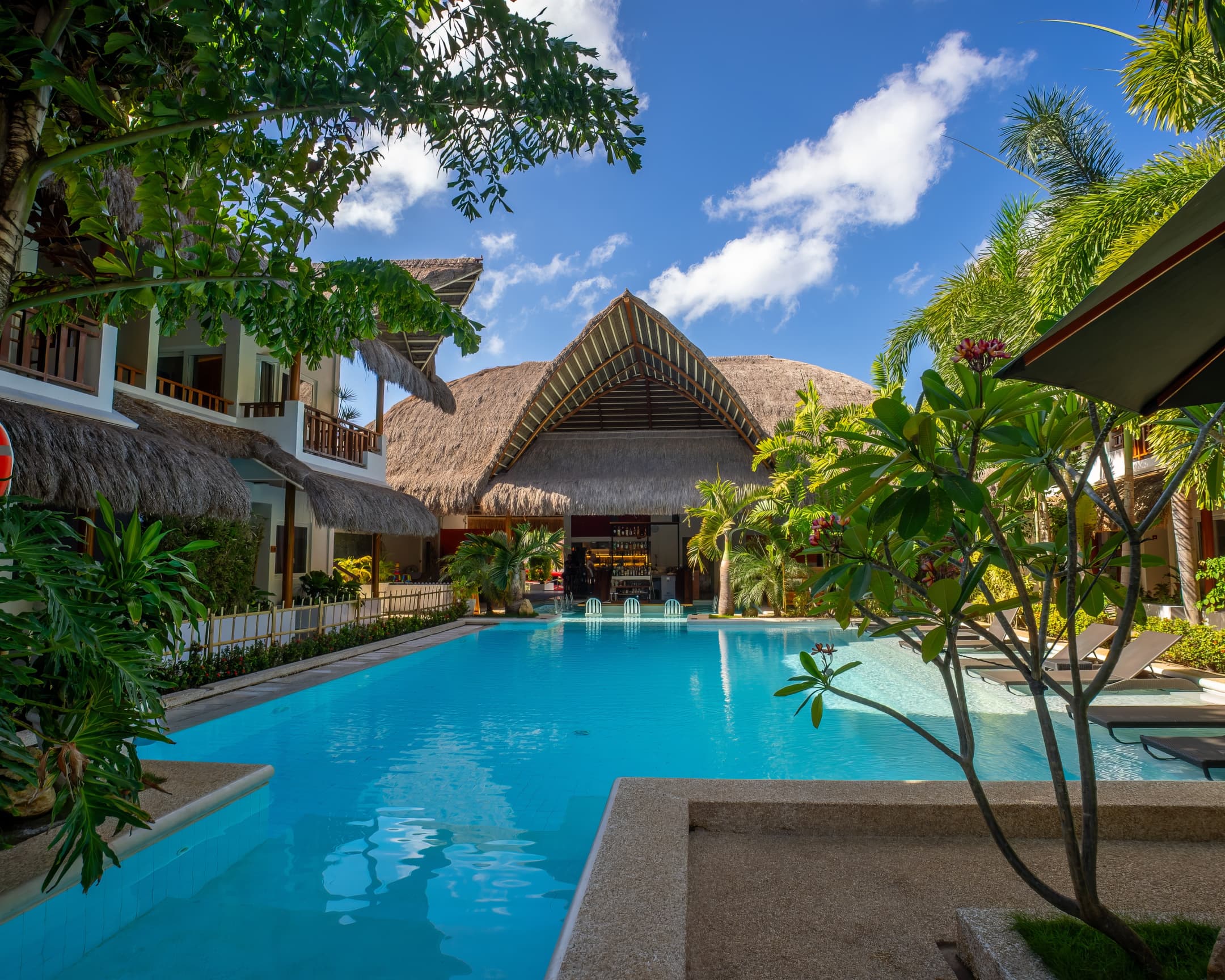 Pool framed by tropical trees at Bathala Resort