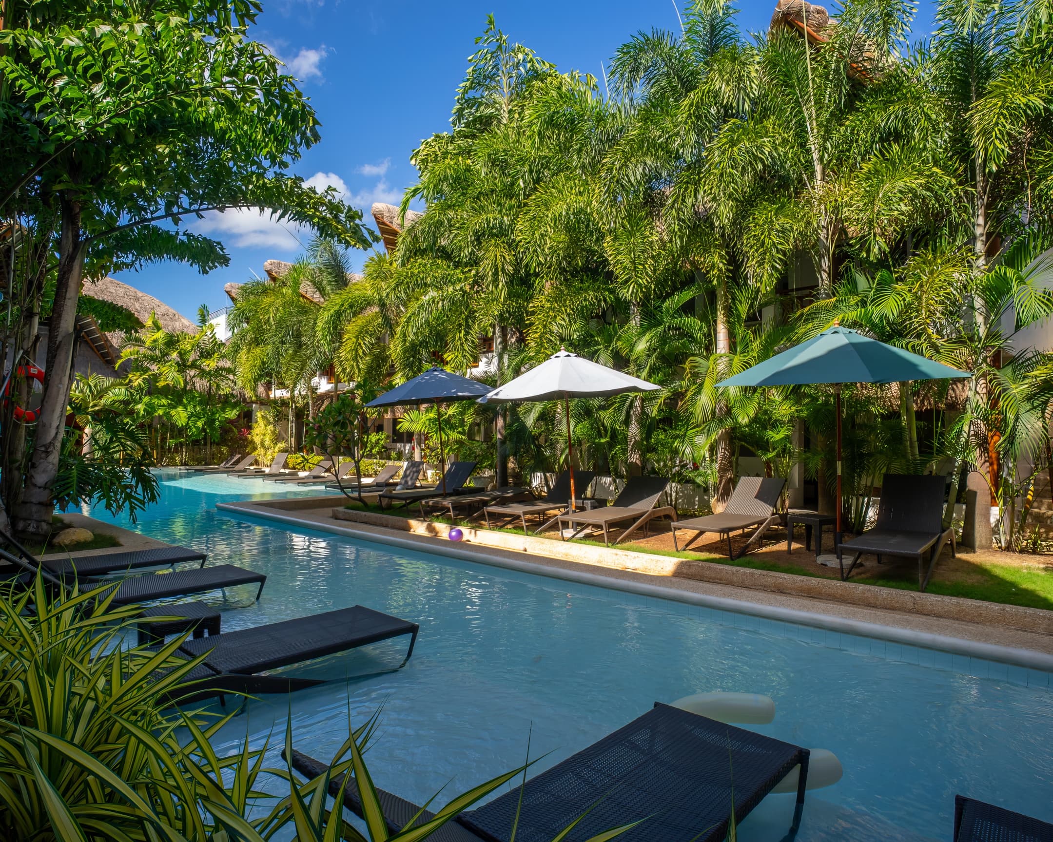 Poolside loungers and umbrellas at Bathala Resort
